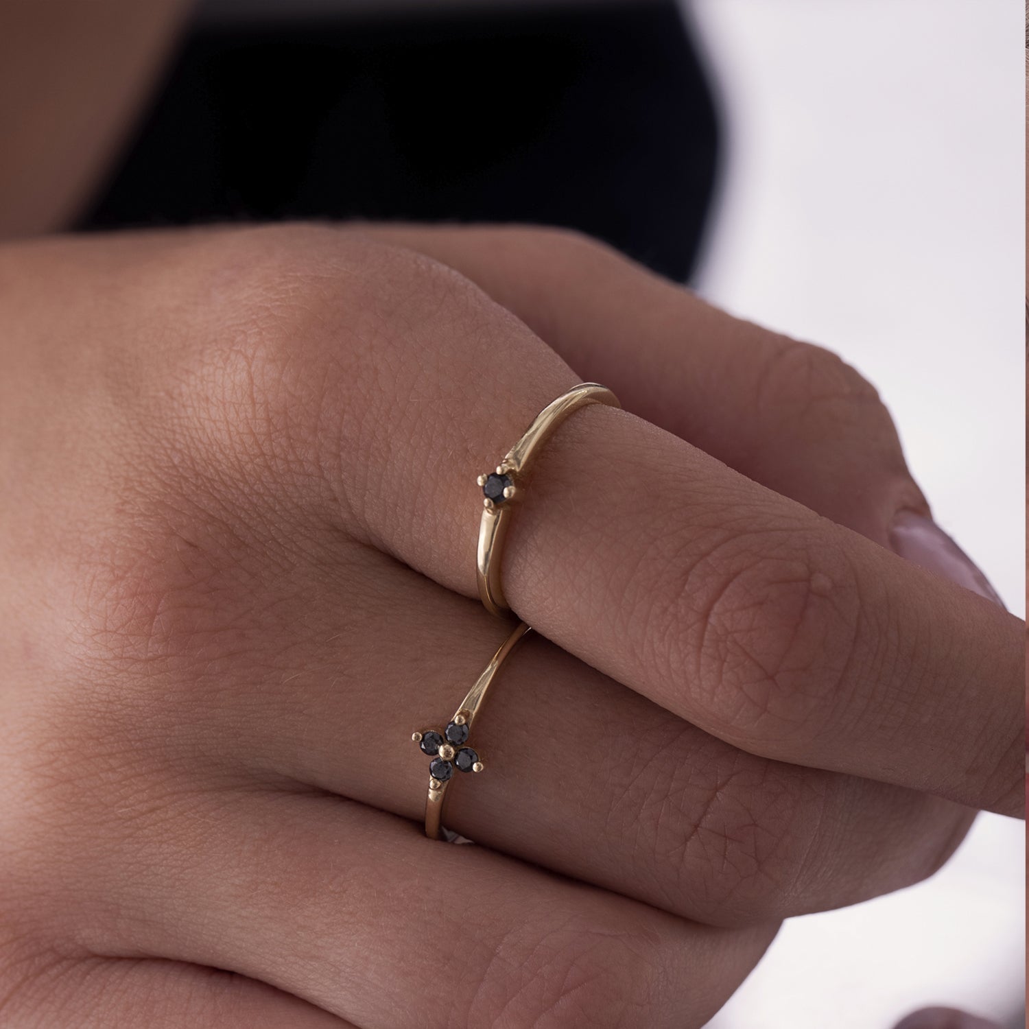 Delicate gold ring with black diamonds in the shape of a flower