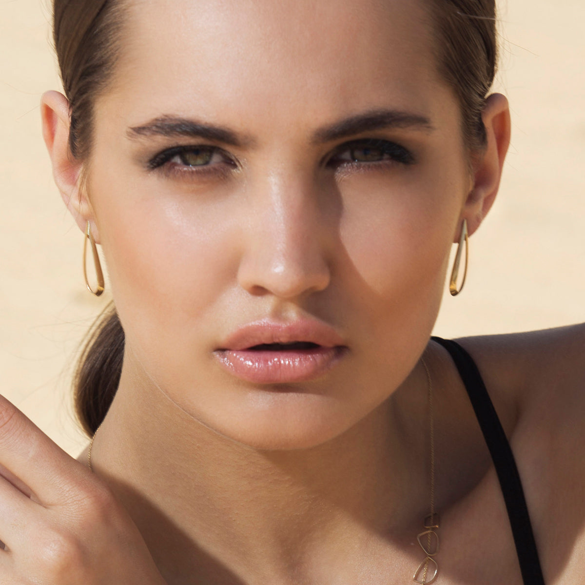 Large tight gold earrings in the shape of a drop