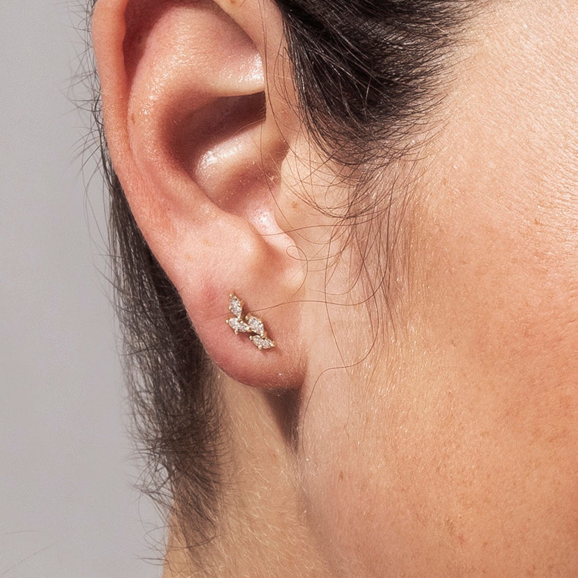 Close-up gold earrings in the shape of leaves set with marquise-cut diamonds