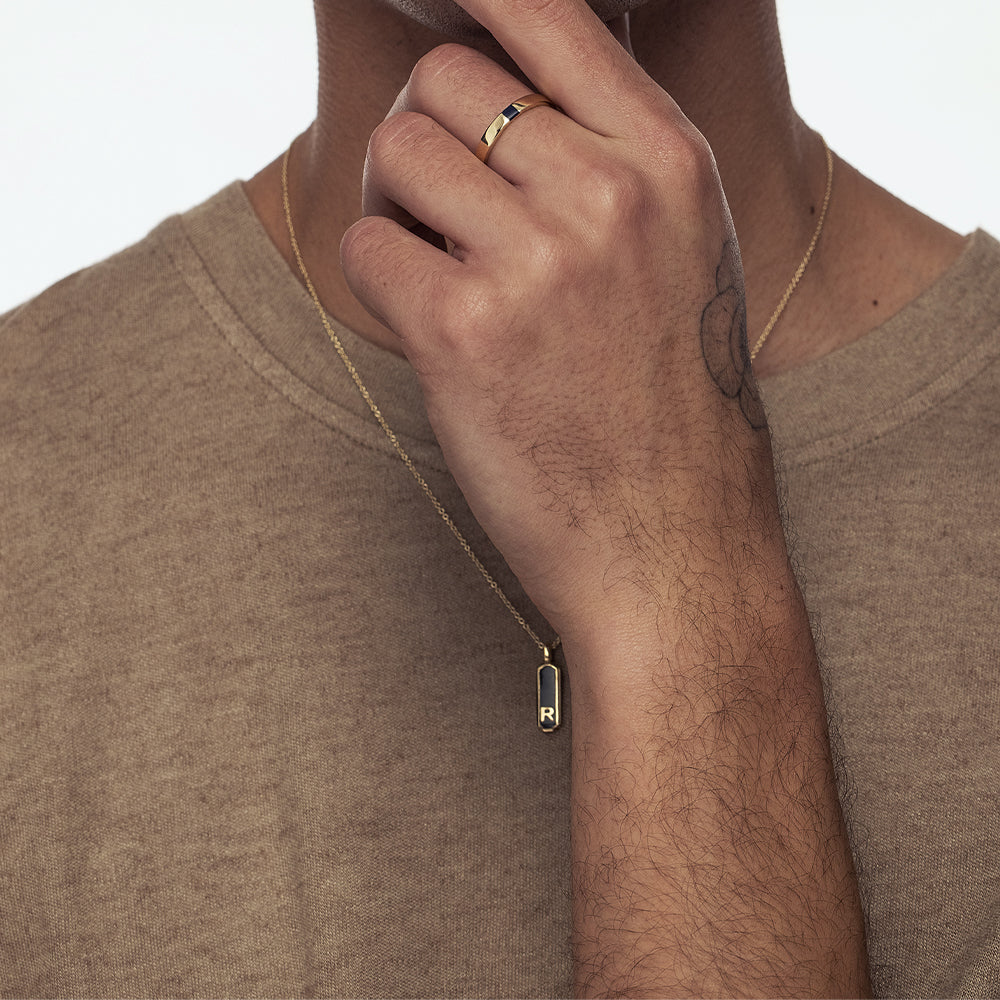 Gold necklace with two-sided narrow letter pendant combined with enamel