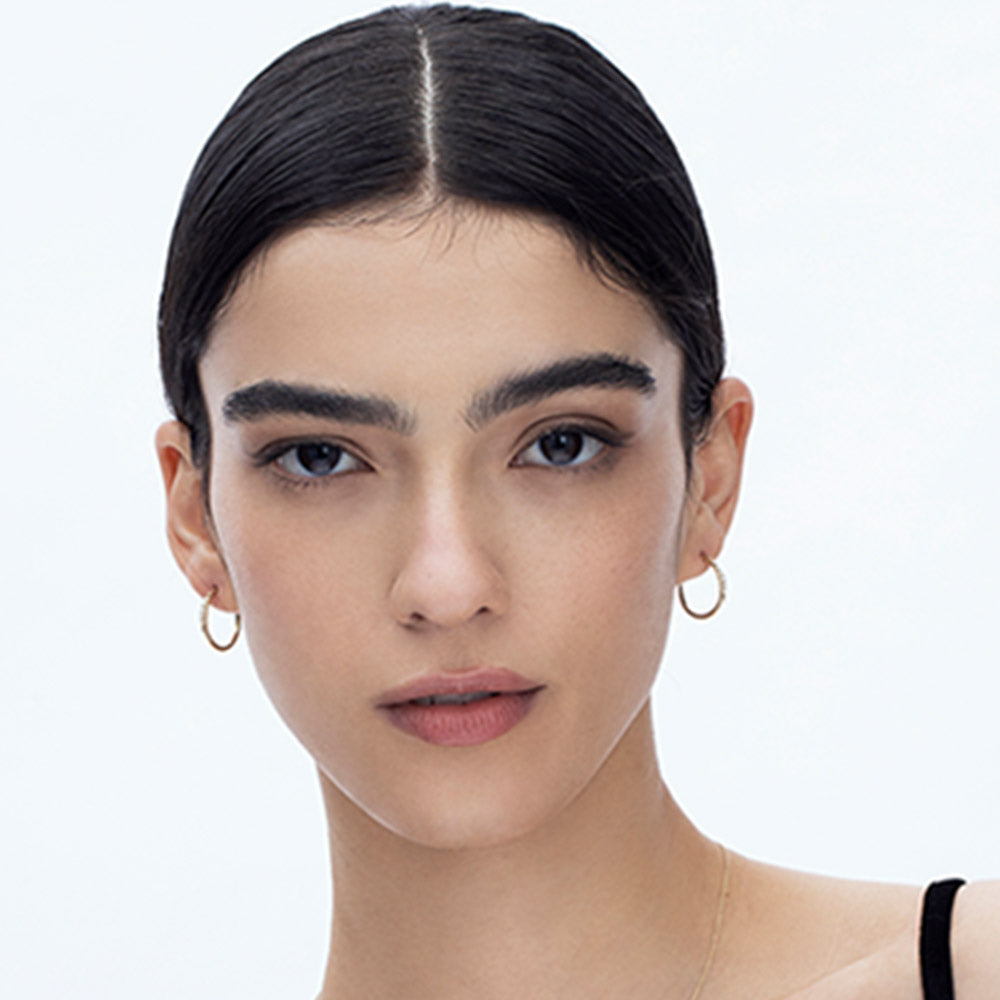 Delicate gold hoop earrings set with a row of 5 diamonds of different sizes