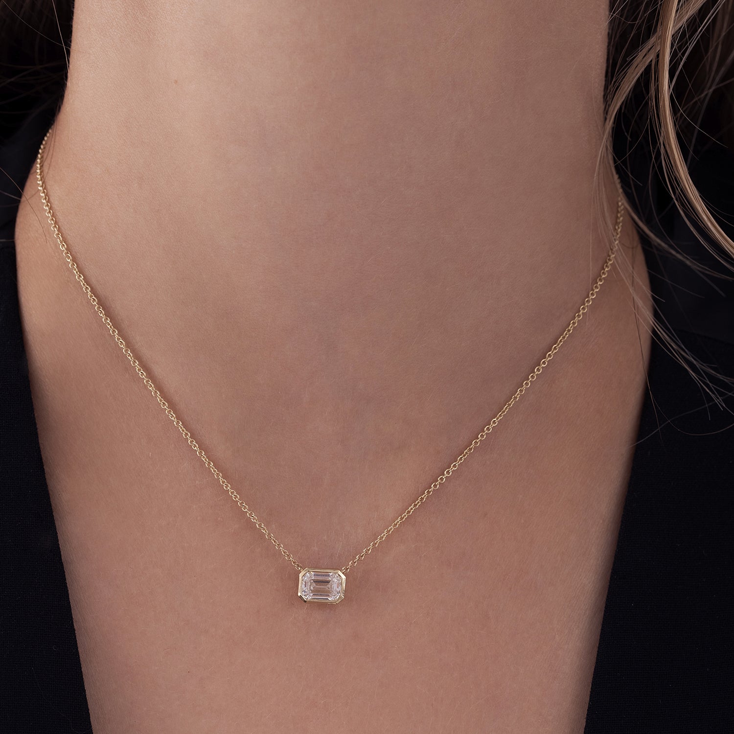 A classic gold necklace set with a 1 carat emerald cut lab diamond