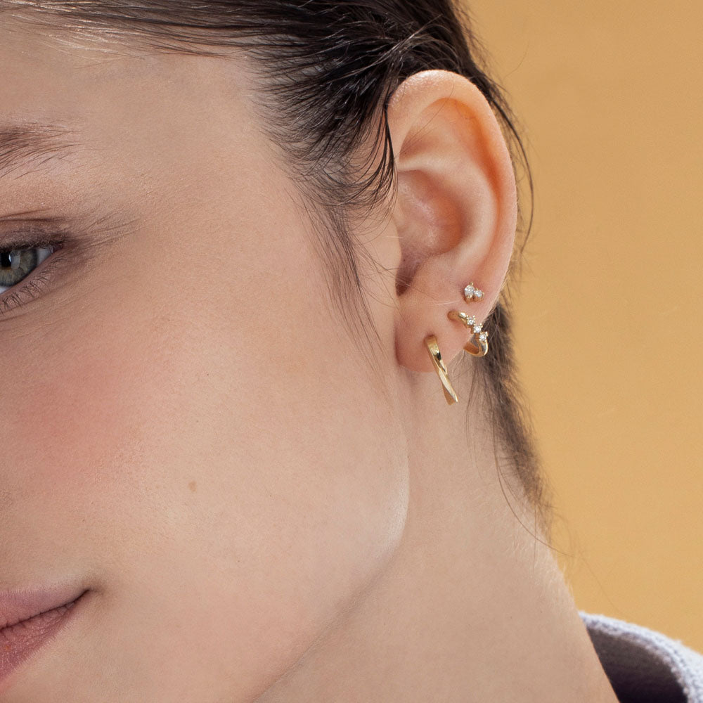 Small gold hoop earrings with a special setting of 3 white diamonds in each earring