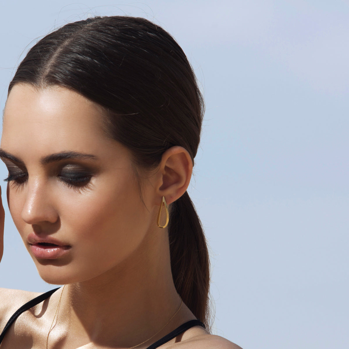 Large tight gold earrings in the shape of a drop