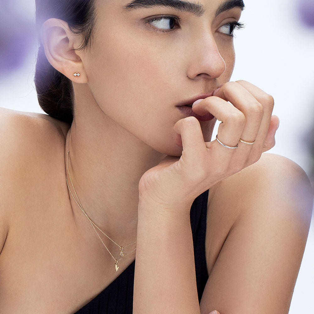 A thin gold ring with a round profile set with a row of five diamonds