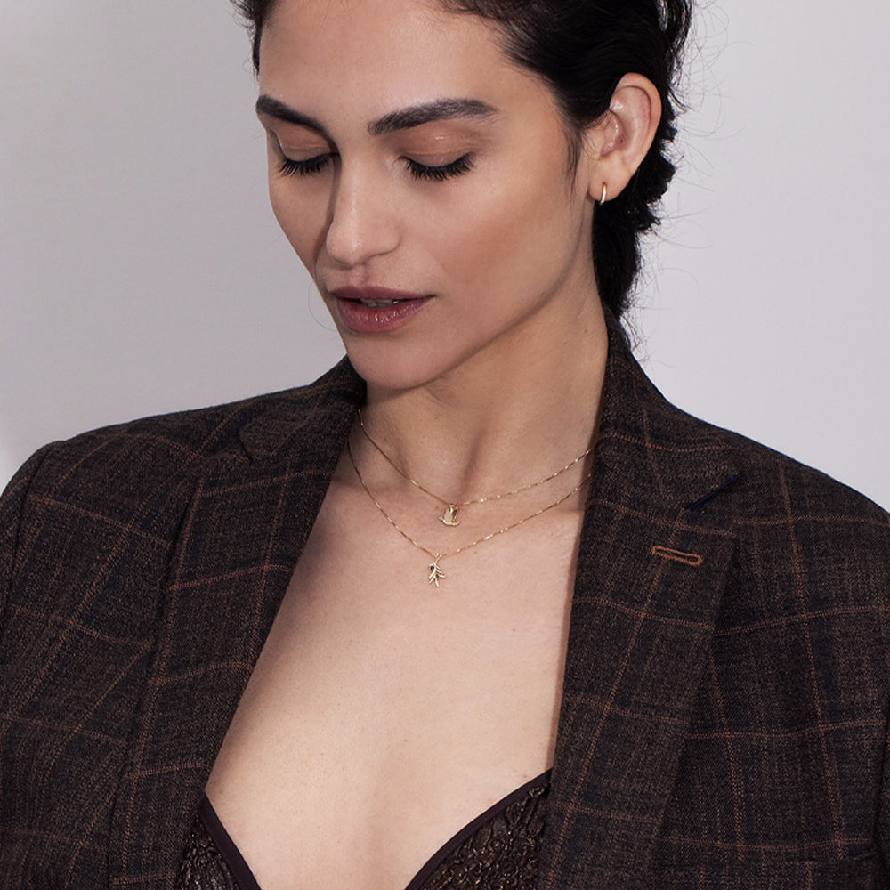 Gold necklace with an olive leaf pendant studded with tourmalines