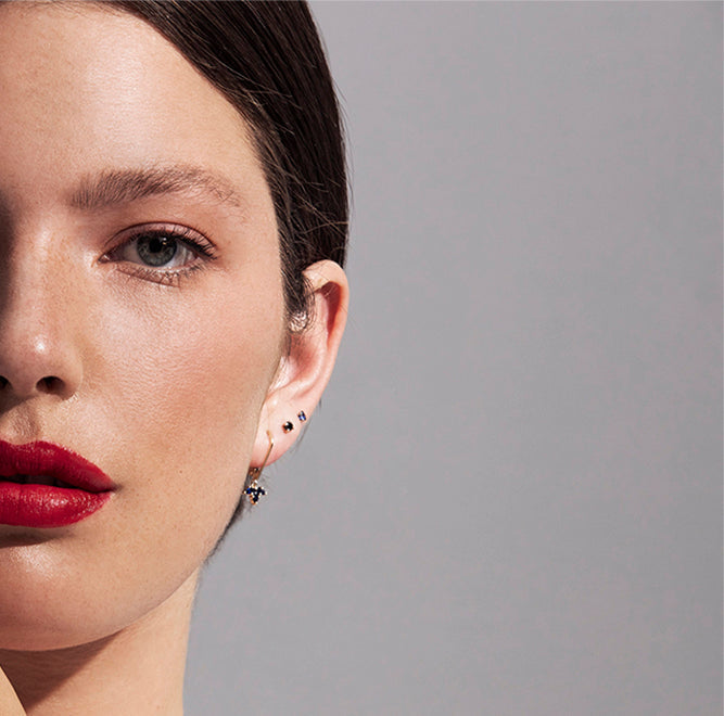 Gold solitaire earrings studded with black diamonds
