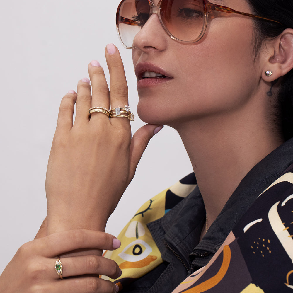 A double gold ring set with a row of diamonds and a smooth wide band