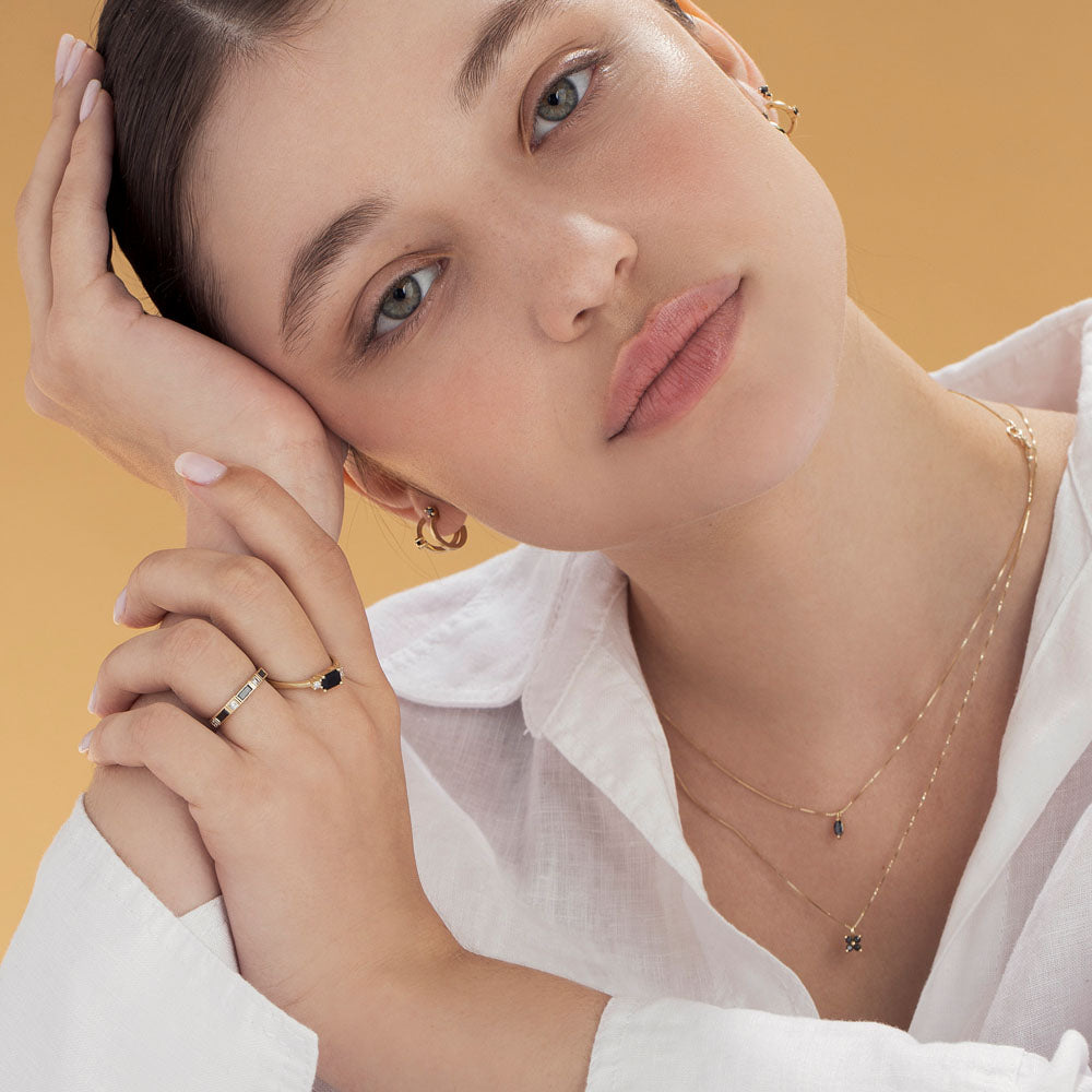Delicate gold necklace for women with 4 black diamonds in the shape of a horizontal flower