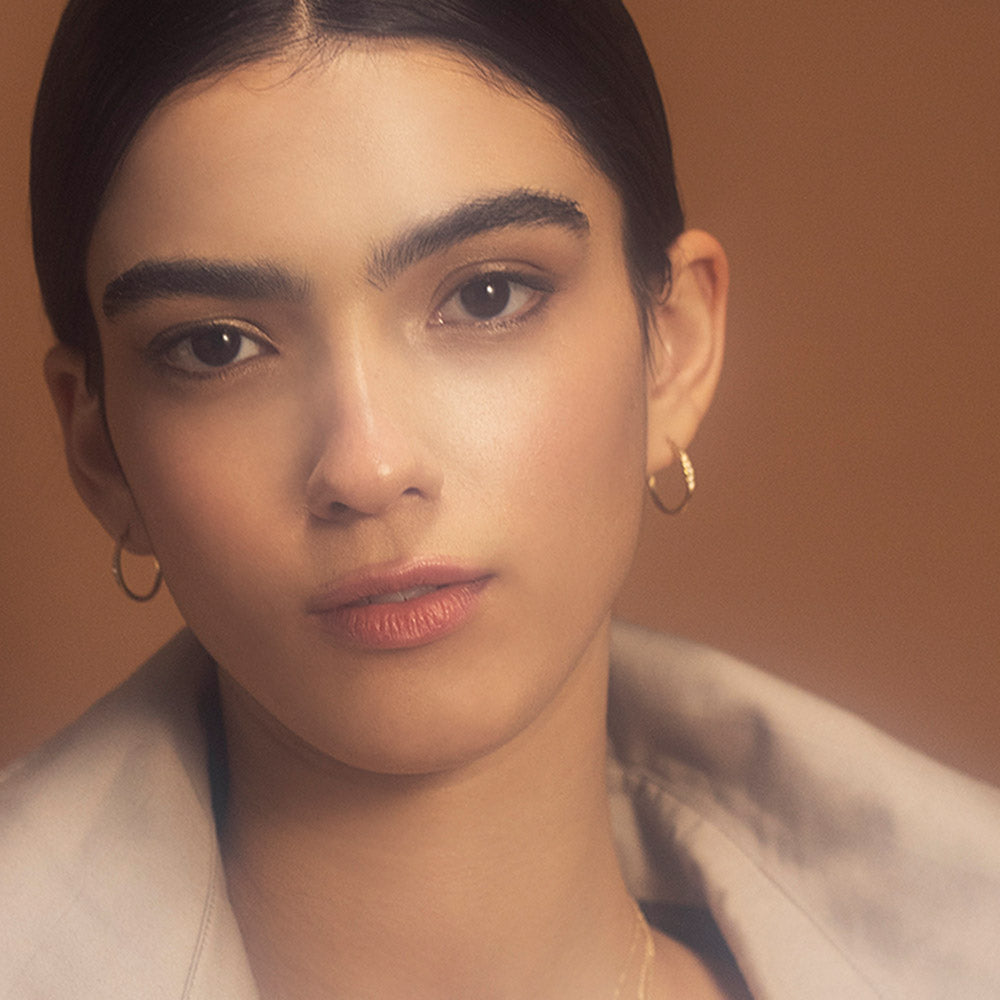 Delicate gold hoop earrings set with a row of 5 diamonds of different sizes