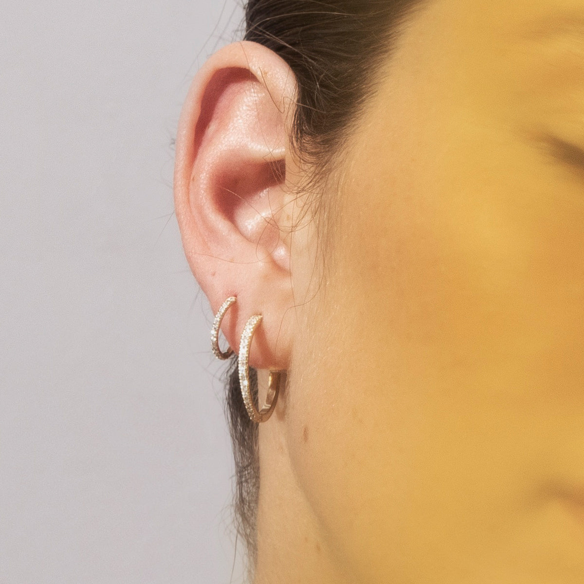 Thin hoop earrings studded with white diamonds