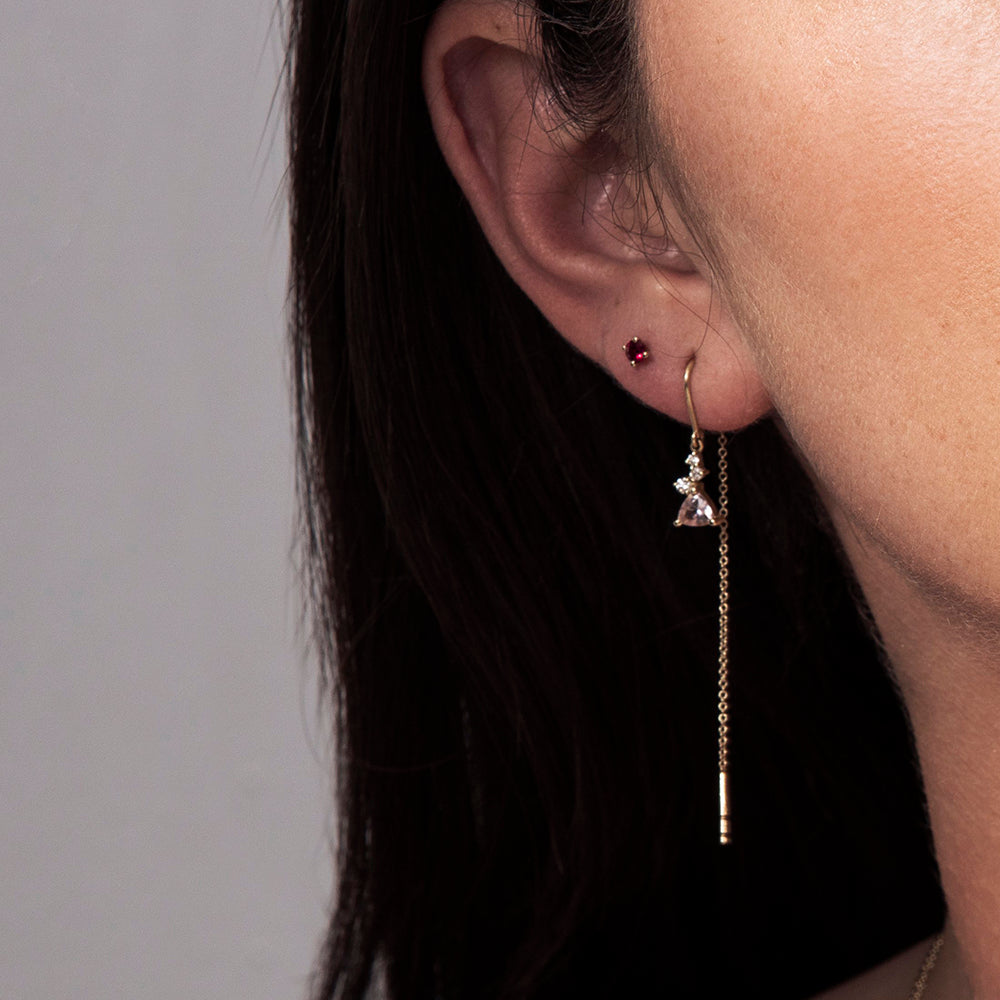 Gold earrings with a chain set with trillion-cut morganite and small diamonds of varying sizes