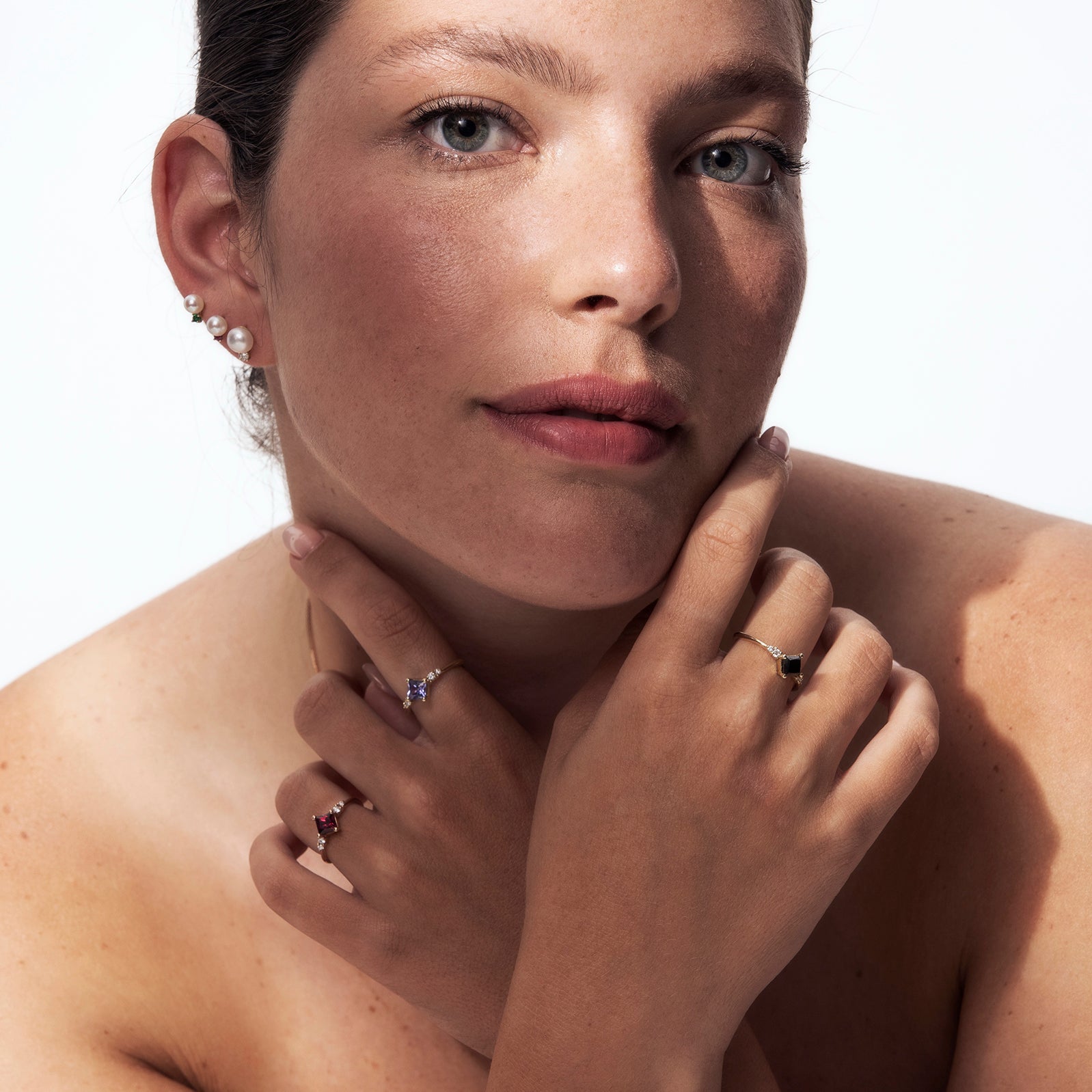 A gold ring set with princess-cut tanzanite and diamonds on the sides