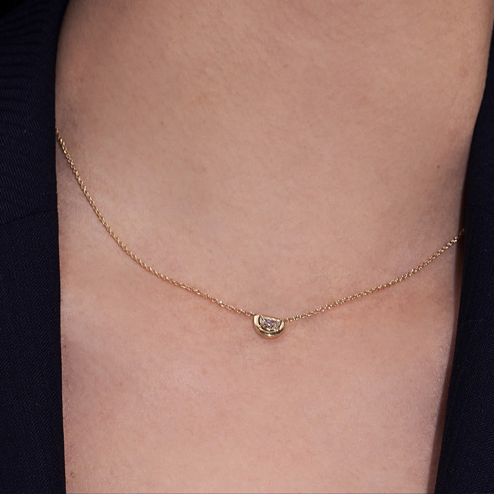 A special gold chain set with a diamond in a semi-circle cut in a modern design