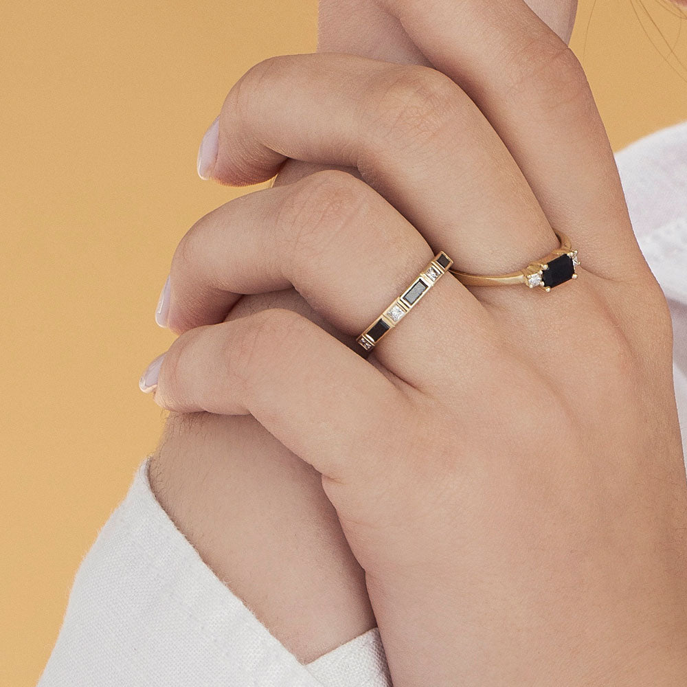 A semi-eternity ring set with baguette-cut black diamonds and princess-cut white diamonds