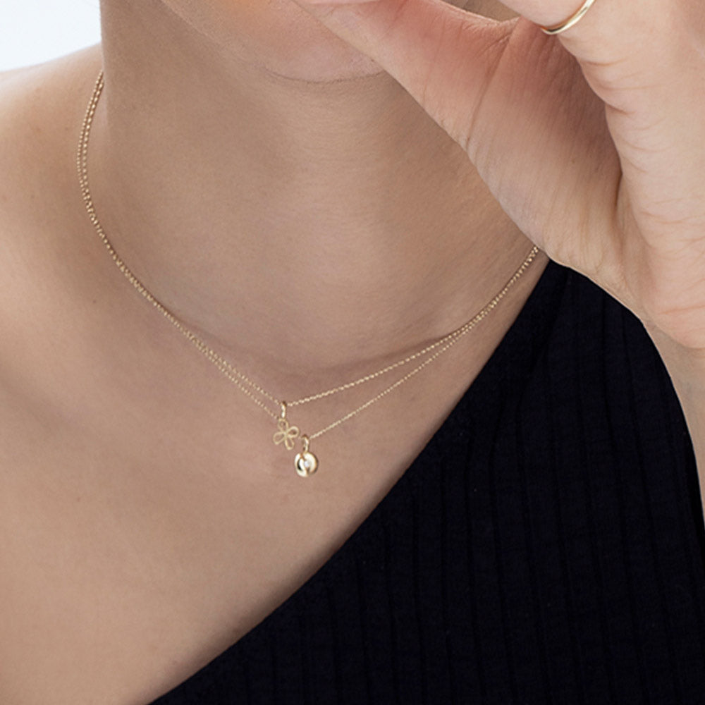 A fine gold chain with a pendant in the shape of a flower