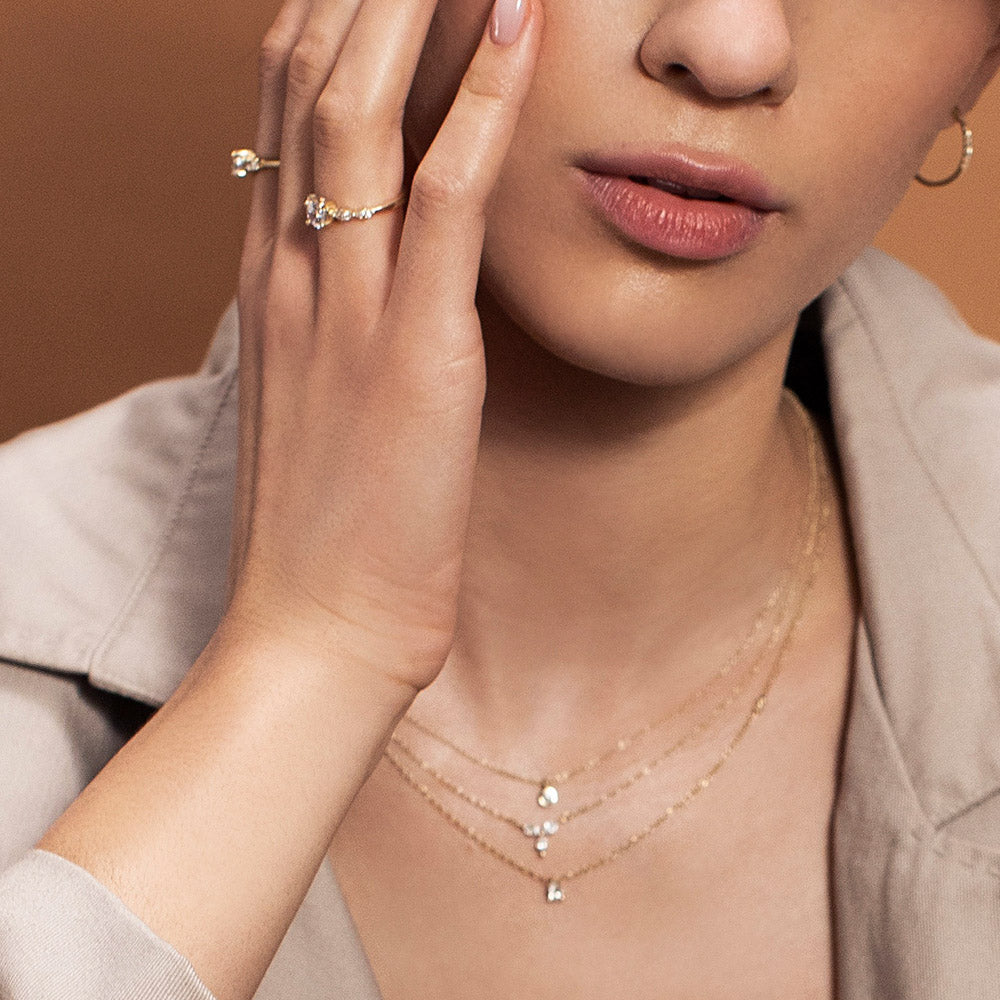 A gold chain set with a drop-cut diamond and a round diamond on the side