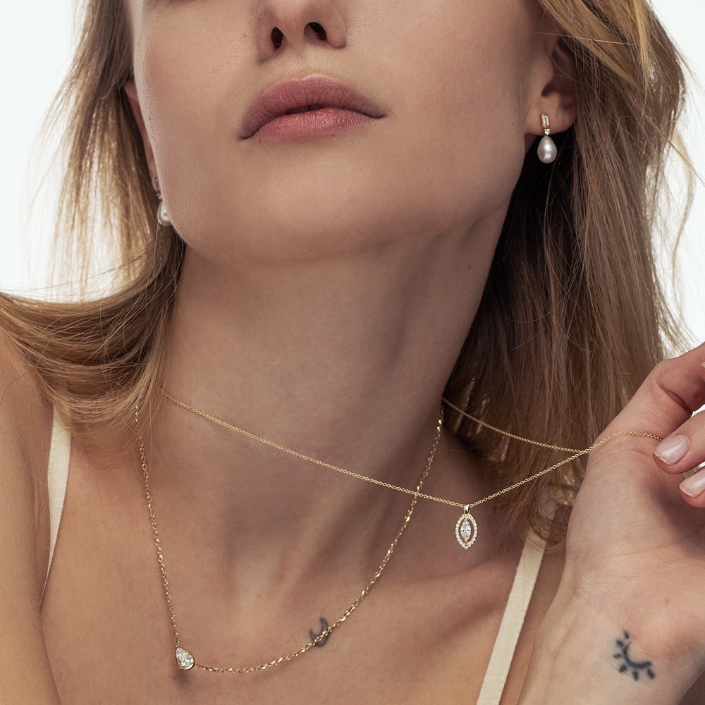 A special gold chain set with a laboratory diamond in a horizontal drop cut