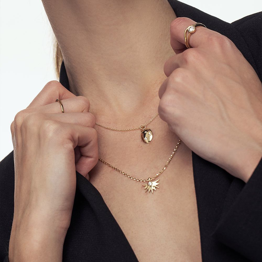 An amorphous gold chain set with three lab diamonds of varying sizes