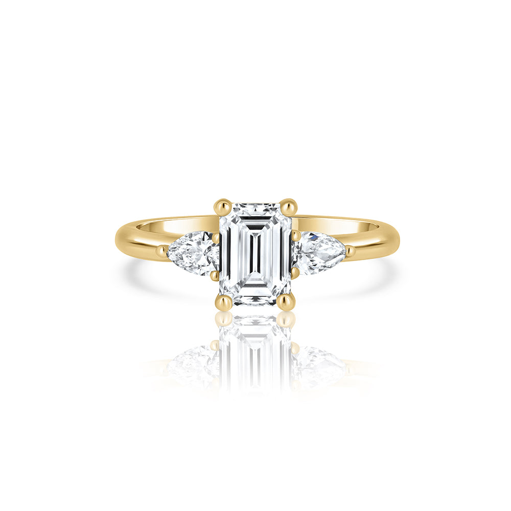 An engagement ring set with laboratory diamonds. Emerald cut central diamond and two drops