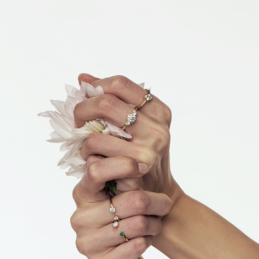 Open gold and diamond ring. A ring set with a laboratory diamond weighing 30 points and a natural emerald.