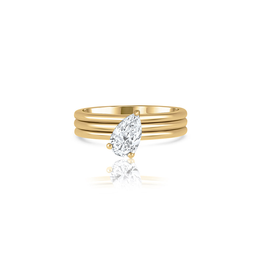 A wide gold ring set with a drop-cut lab diamond
