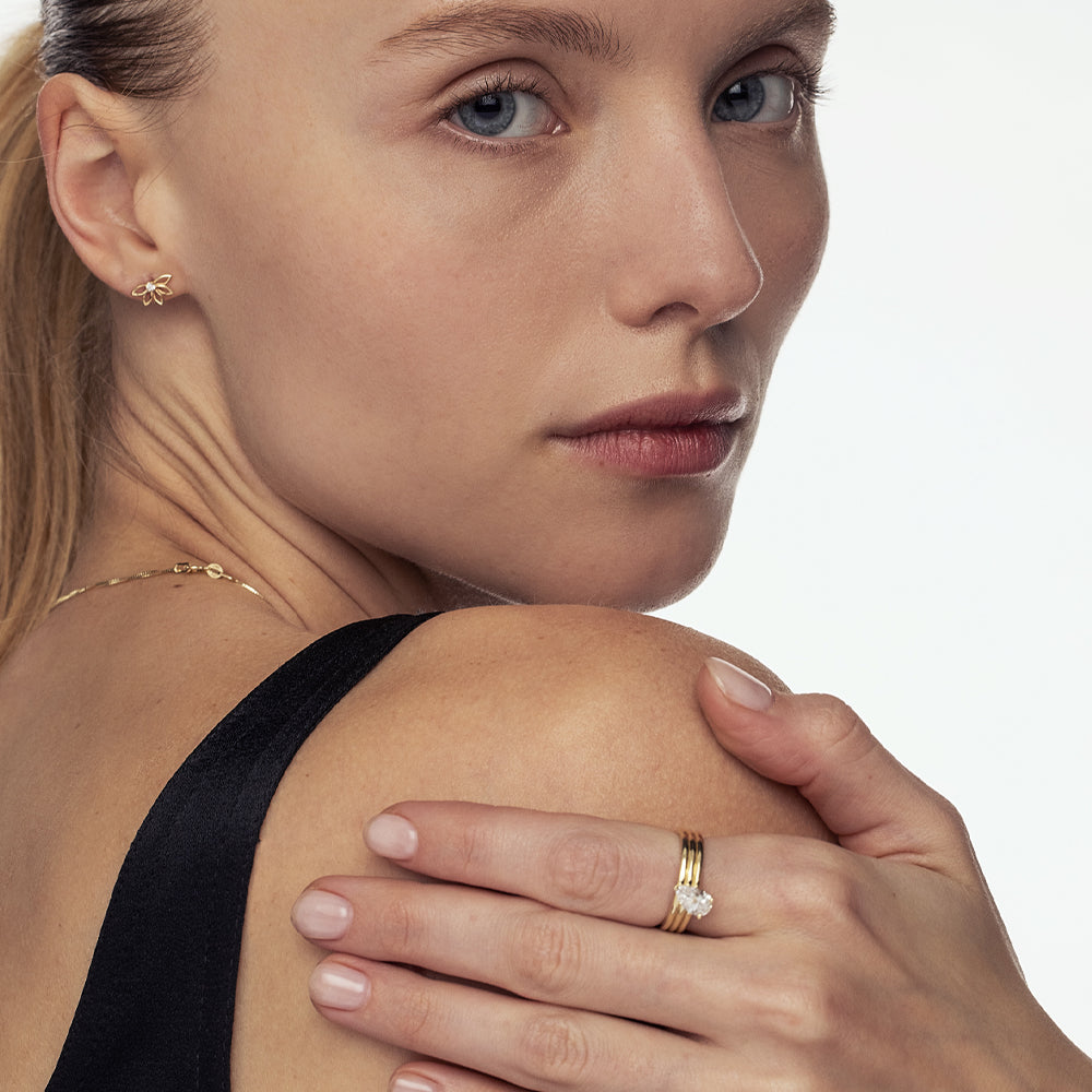 A wide gold ring set with a drop-cut lab diamond