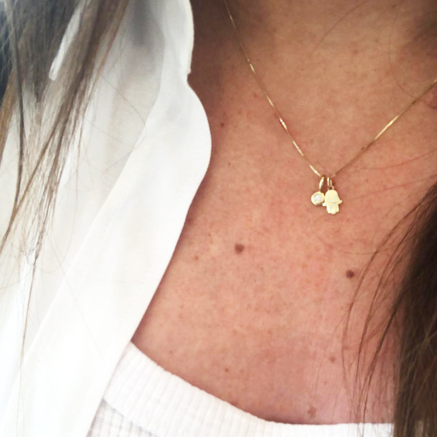 A flat Hamsa gold chain combined with a diamond pendant