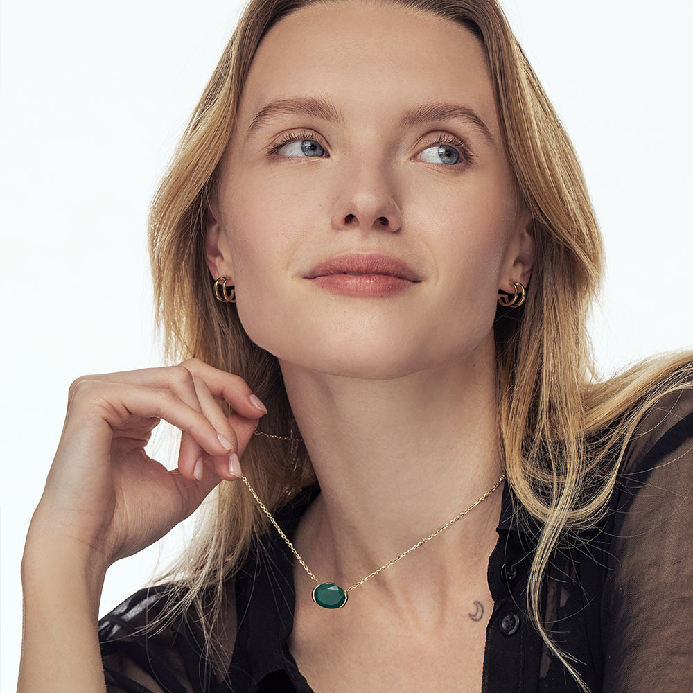 A gold chain inlaid with a green onyx stone, impressive in an oval cut