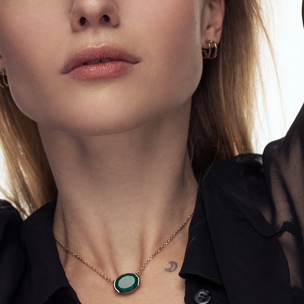 A gold chain inlaid with a green onyx stone, impressive in an oval cut