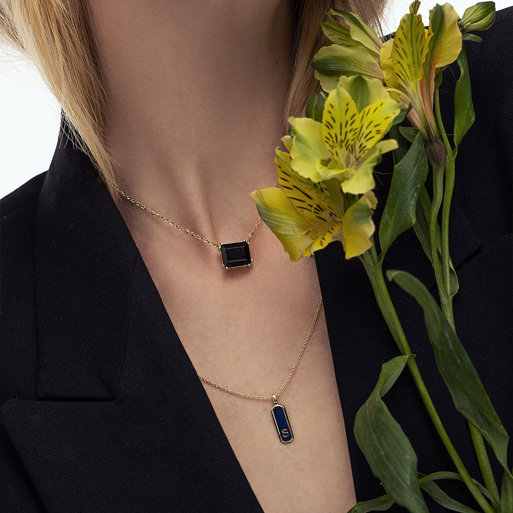 A gold necklace for a woman inlaid with a rectangular black onyx
