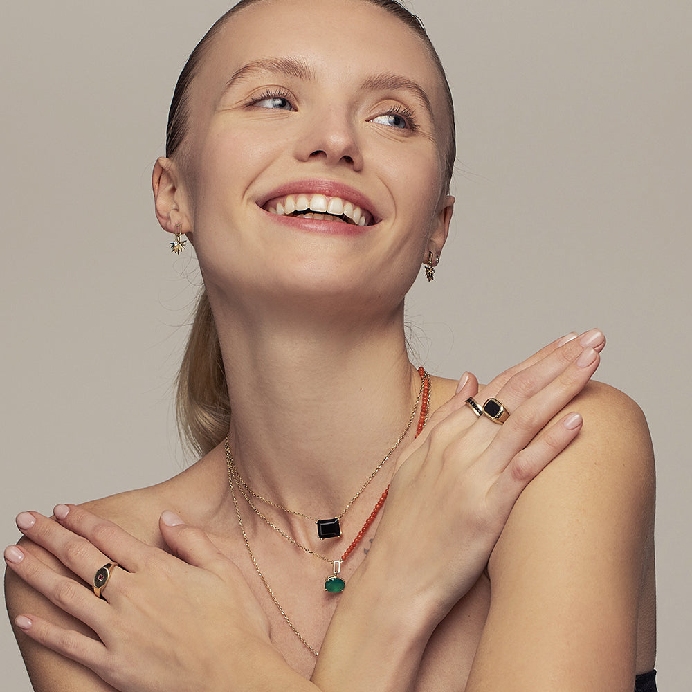 A gold necklace for a woman inlaid with a rectangular black onyx