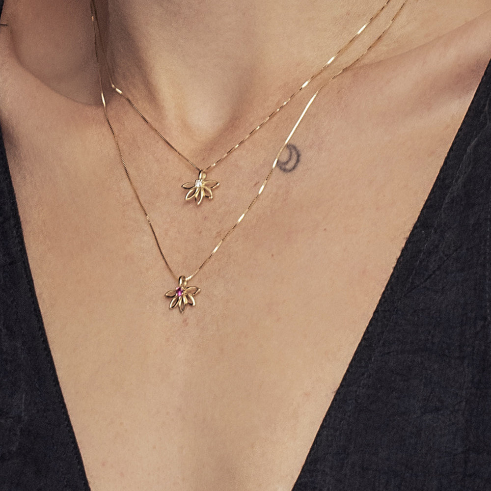 A delicate gold flower necklace set with a laboratory diamond