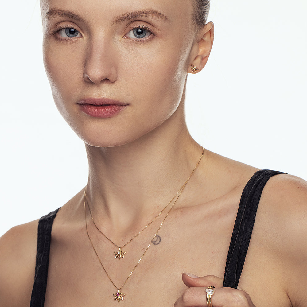 A delicate gold flower necklace set with a laboratory diamond