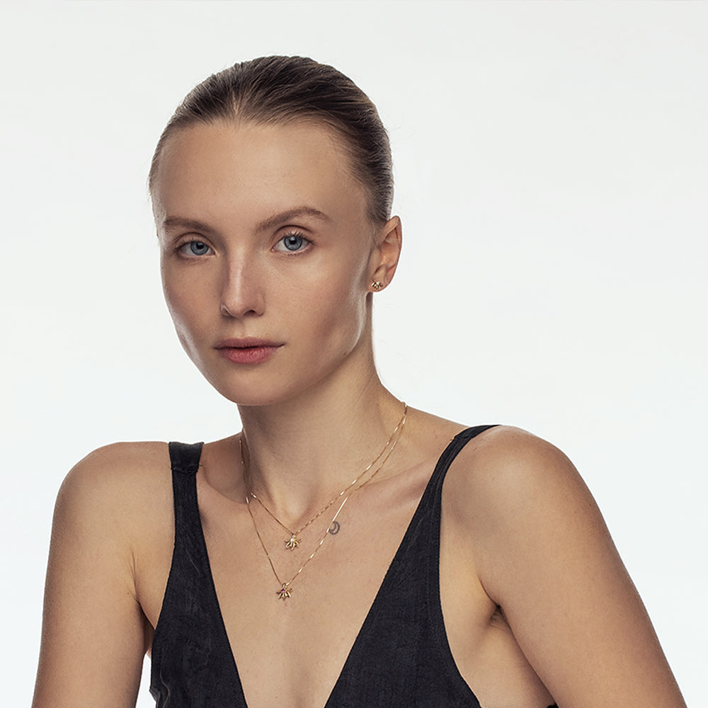 A delicate gold flower necklace set with a laboratory diamond