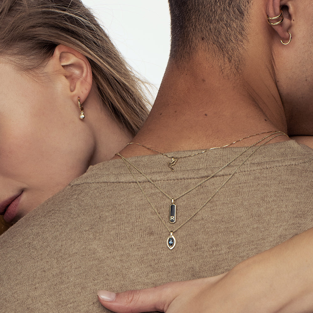 A gold chain with a modern evil eye pendant for men, inlaid with a marquise-cut sapphire