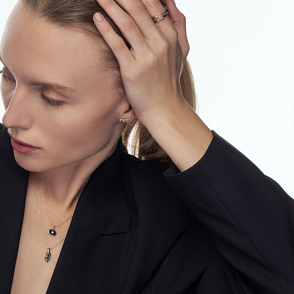 A gold chain with a modern evil eye pendant for men, inlaid with a marquise-cut sapphire