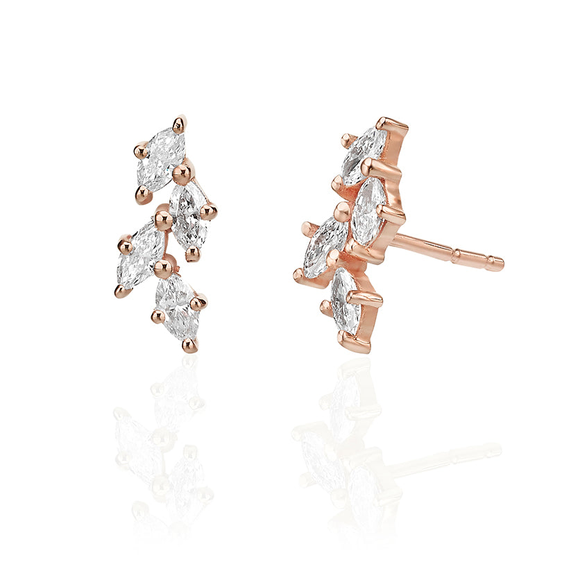 Close-up gold earrings in the shape of leaves set with marquise-cut diamonds