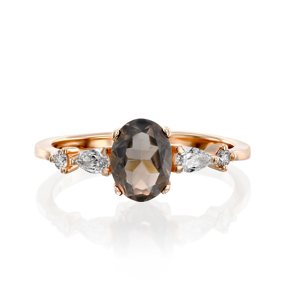 A gold ring set with smoky quartz and drop and round cut diamonds