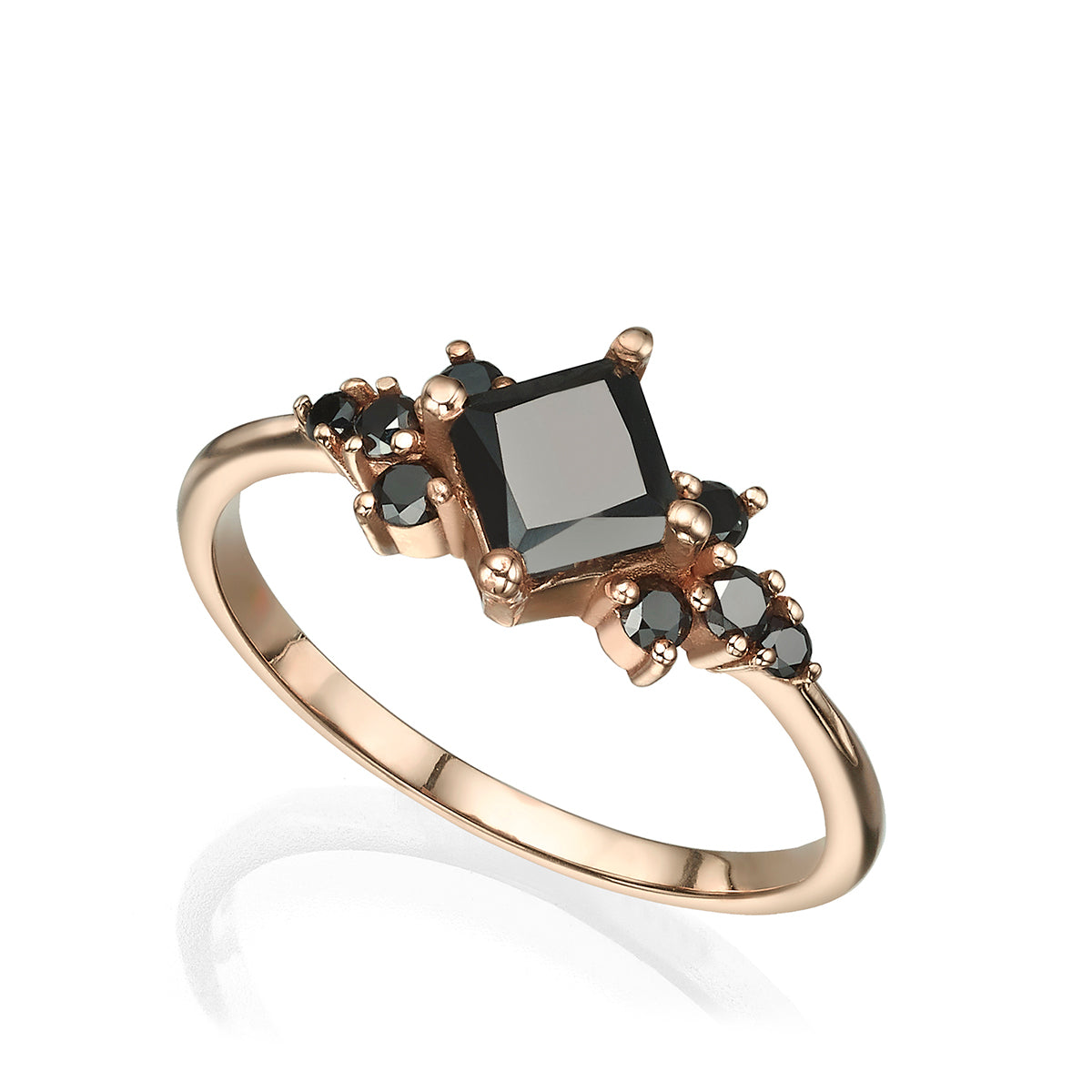 A gold ring set with a princess-cut black diamond and round black diamonds