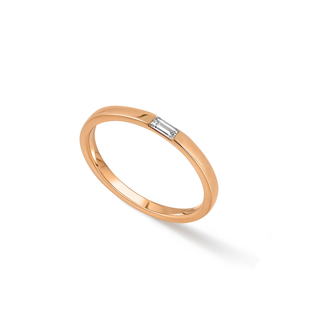 A thin flat gold ring set with a baguette-cut laboratory diamond