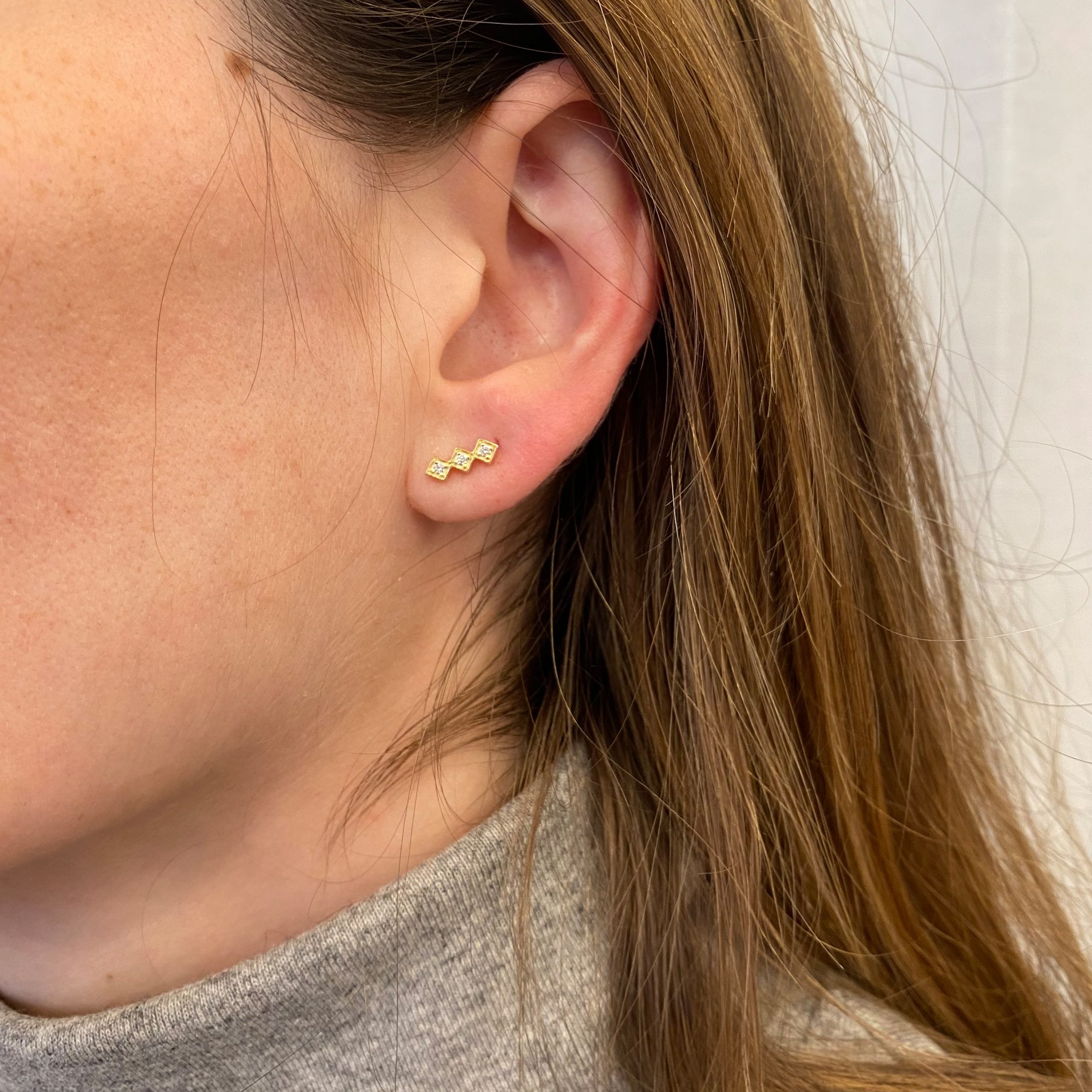 Climbing gold earrings in the shape of three squares studded with diamonds