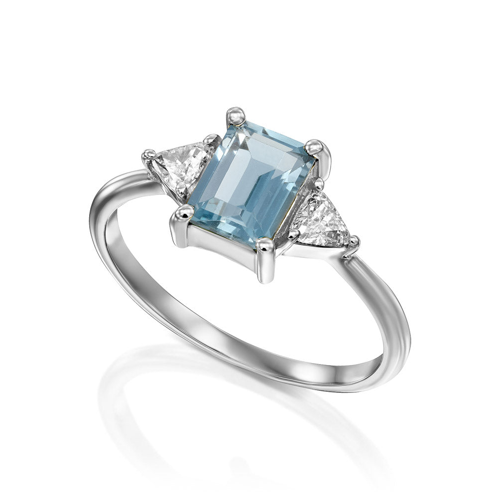 Gold ring set with light London blue topaz and trillion-cut diamonds on the sides