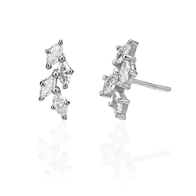 Close-up gold earrings in the shape of leaves set with marquise-cut diamonds