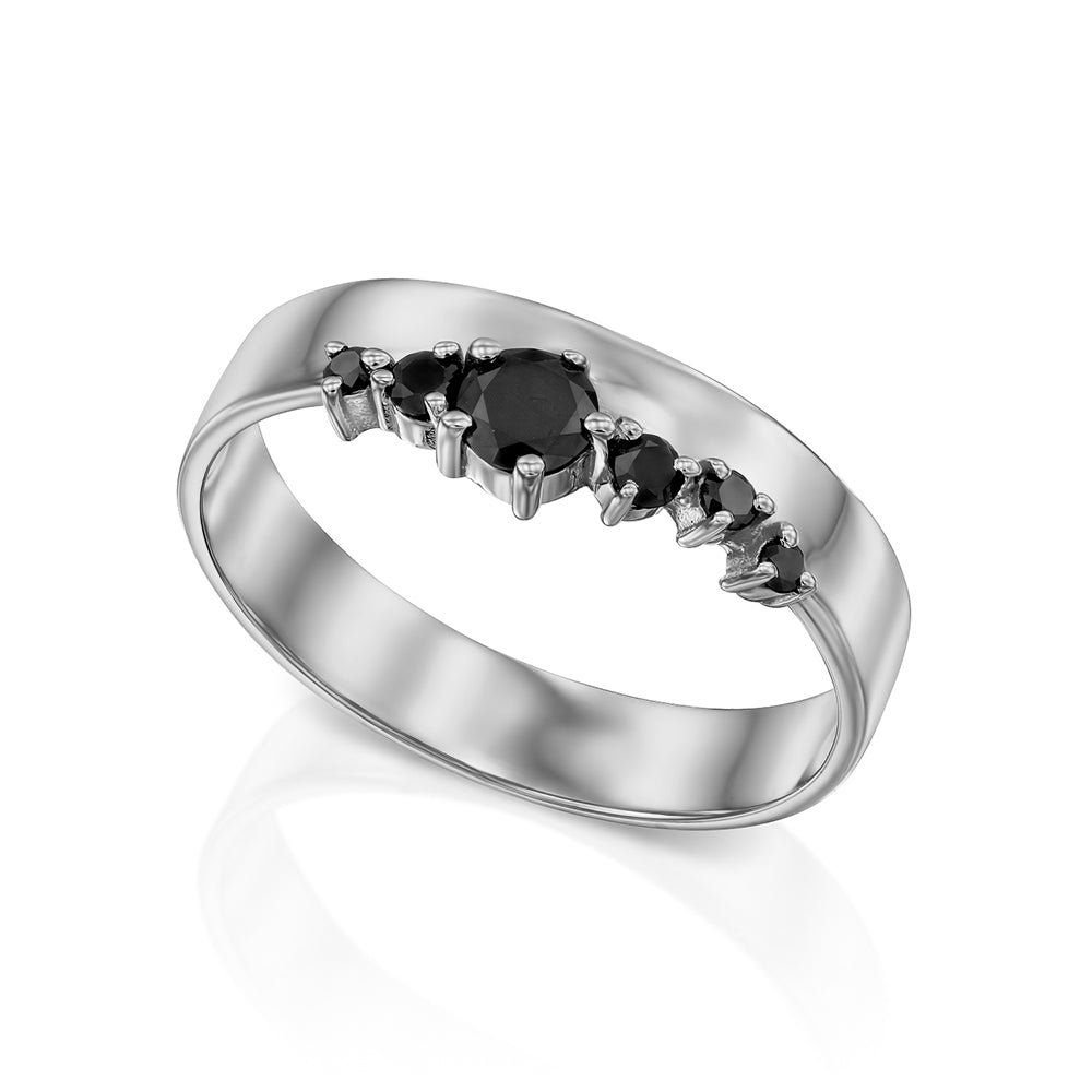 A wide gold ring with a special asymmetrical setting of black diamonds