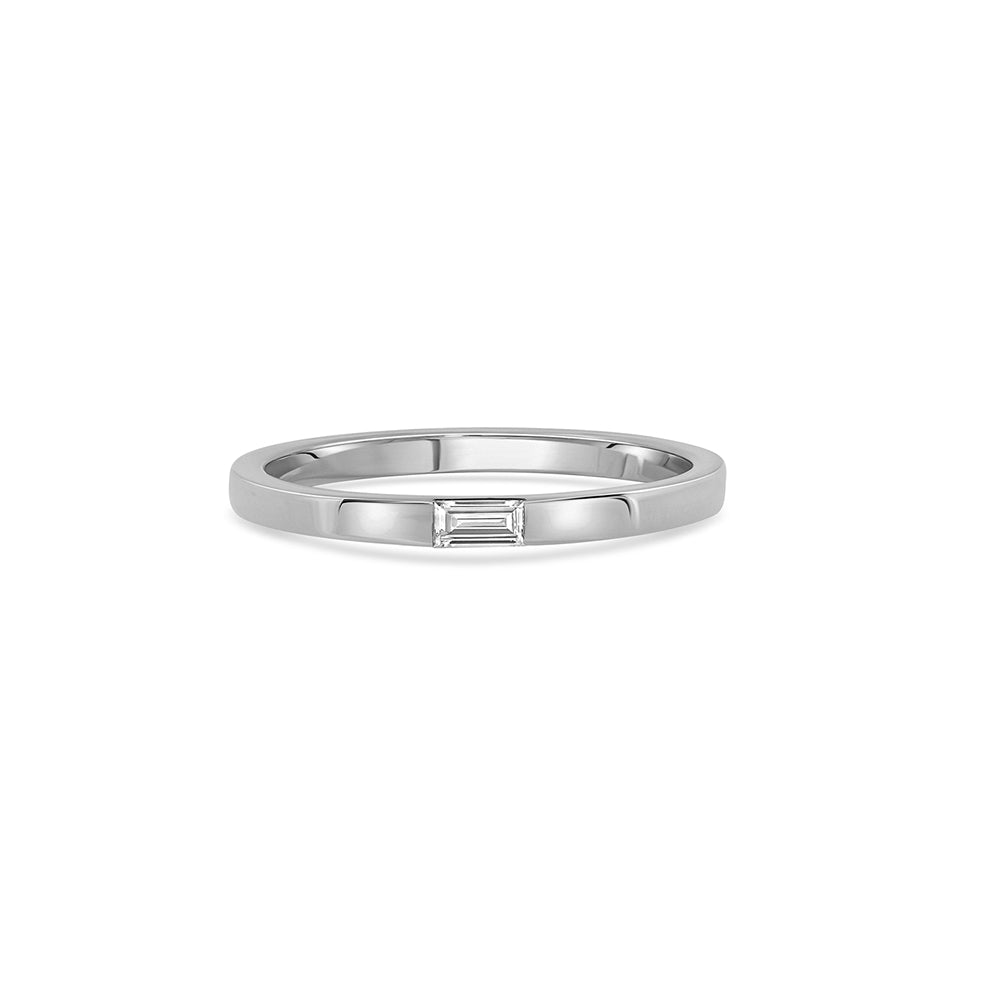 A thin flat gold ring set with a baguette-cut laboratory diamond
