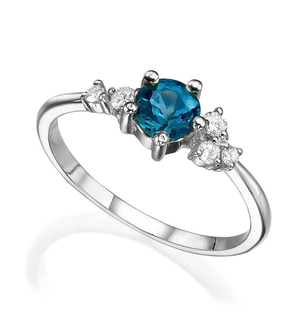 An engagement ring set with London blue topaz and small one-centimeter diamonds