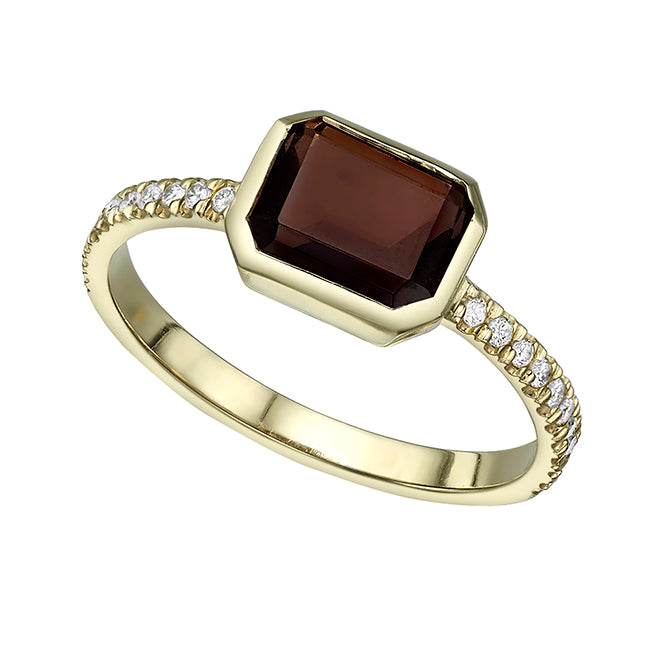 A gold ring set with a smoky quartz stone in a gold frame and white diamonds