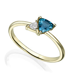 A gold ring set with a diamond and a trillion-cut sapphire