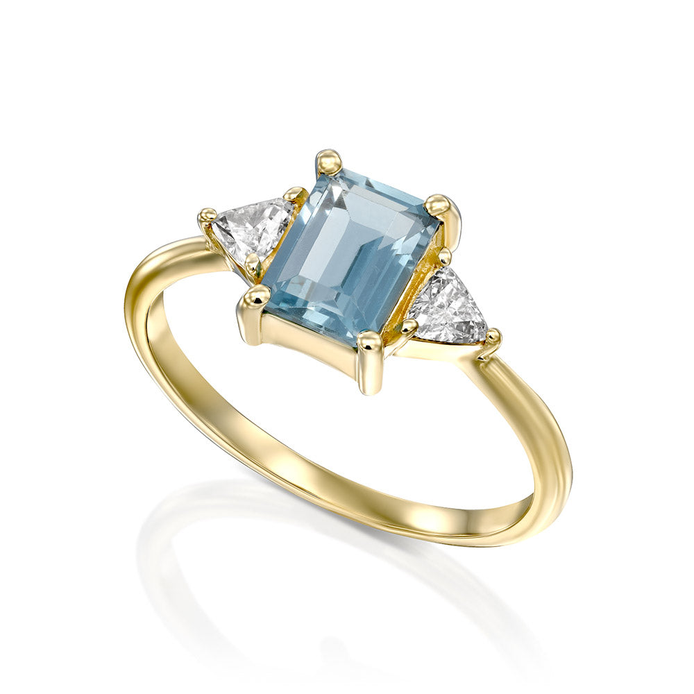 Gold ring set with light London blue topaz and trillion-cut diamonds on the sides
